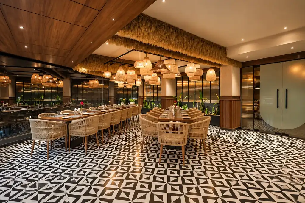 Modern restaurant seating perspective with wicker armchairs and wooden ceiling beams